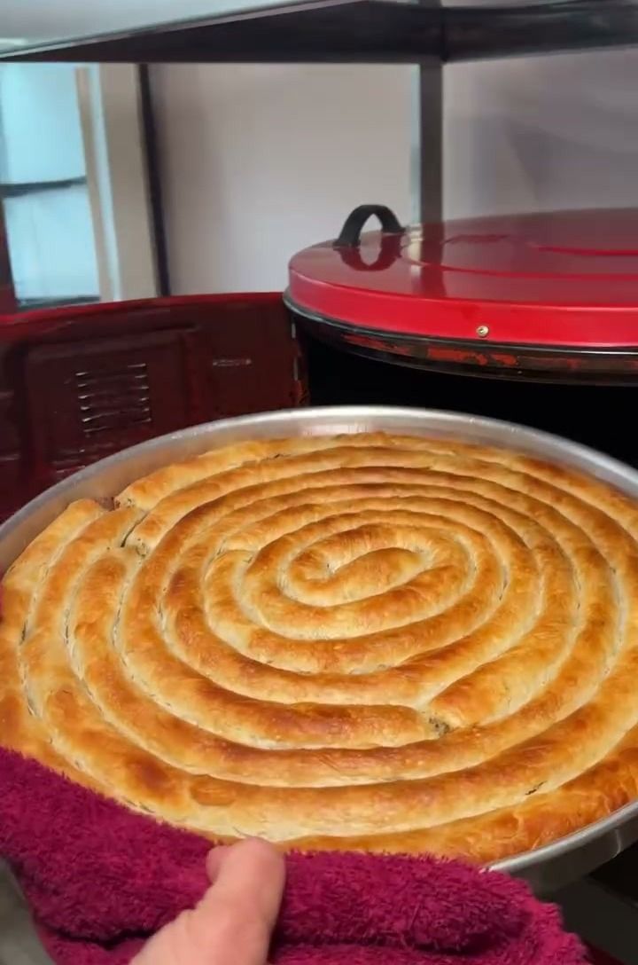 Havluyla tutulan sıcak spiral börek tepsisi