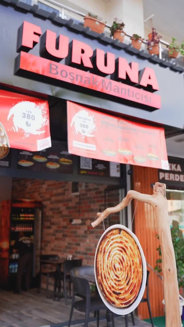 Furuna dükkanının dışarıdan görünümü, kırmızı tabelası ve vitrinde börek tepsisi