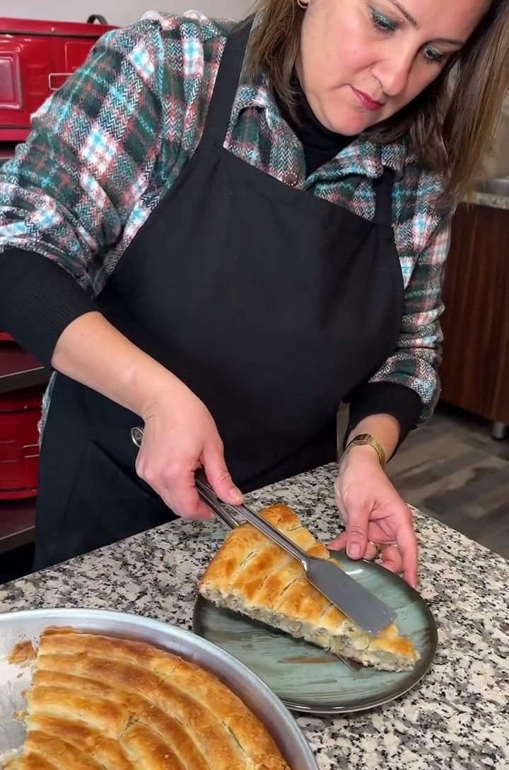 Furuna çalışanı tepsiden sıcak börek dilimini tabağa alıyor