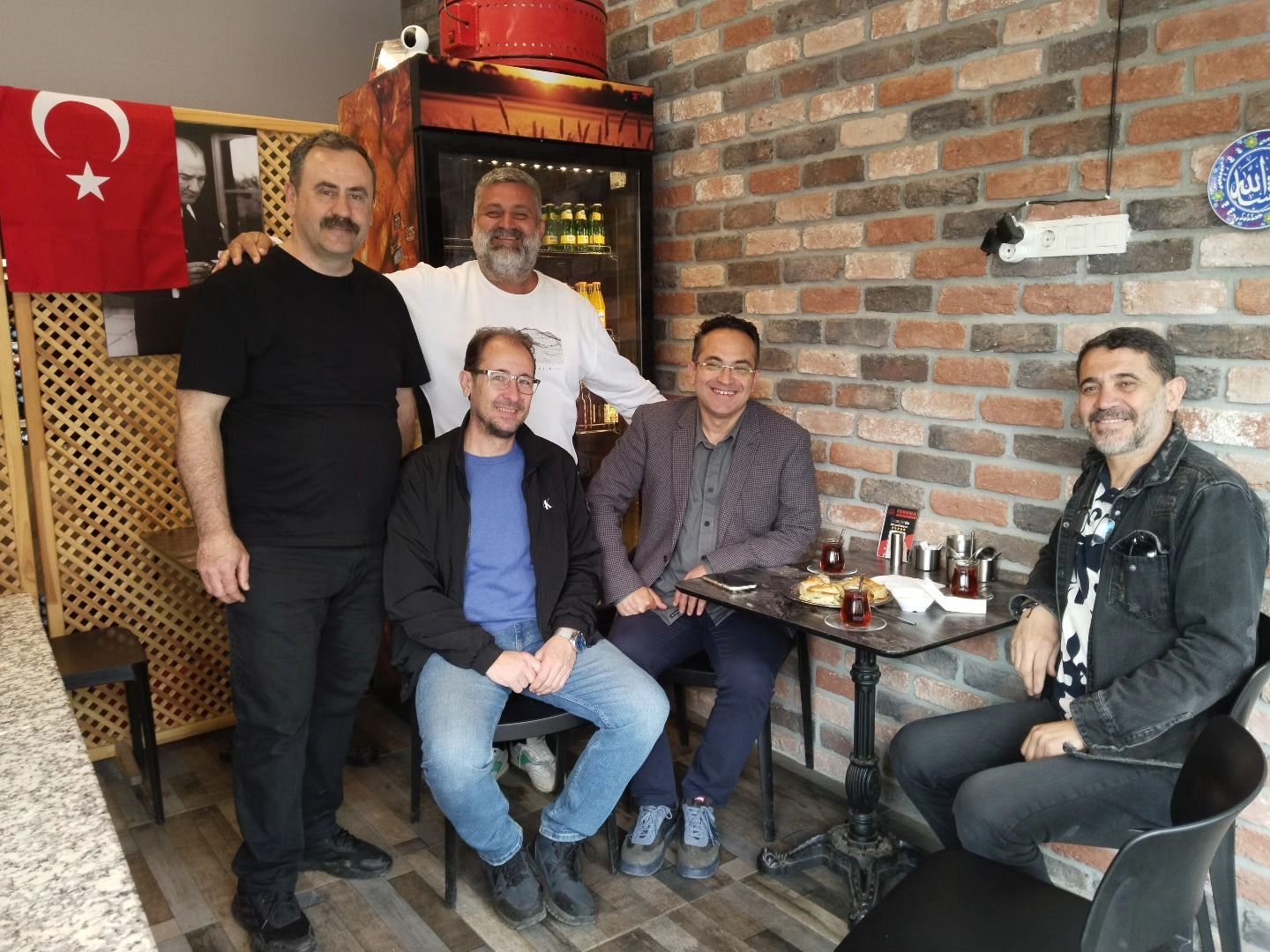 Furuna’da masa başında bir araya gelmiş gülümseyen misafirler