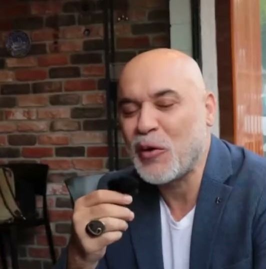 Çay bardağı önünde mantı hakkında konuşan bir misafir
