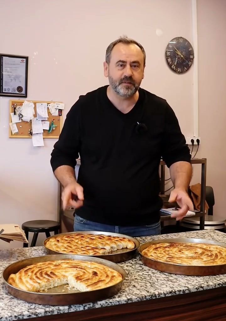 Tezgahta börek tepsilerinin başında misafirleri karşılayan Furuna’dan biri